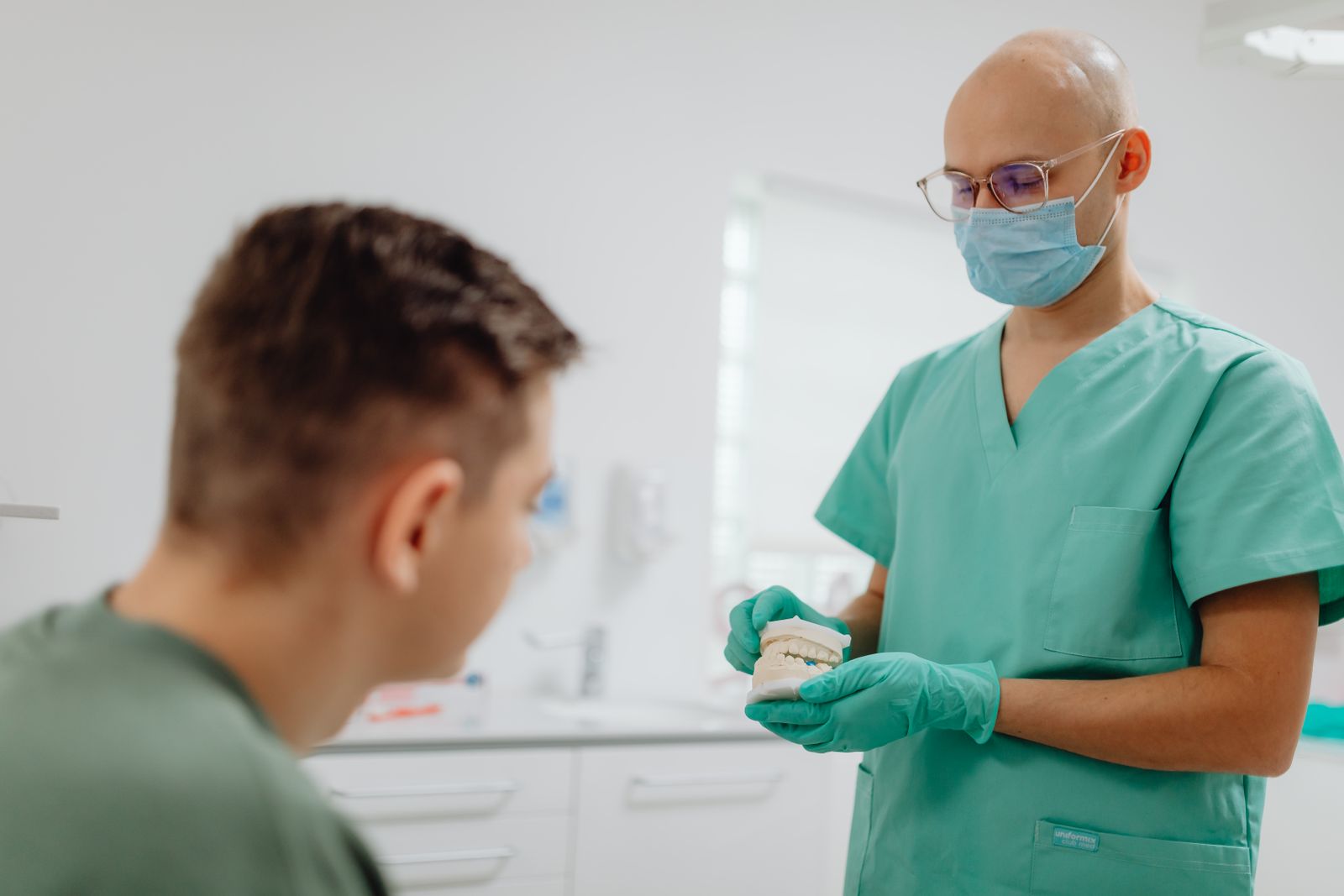 Cirurgia-dentista orientando paciente sobre ortodontia digital